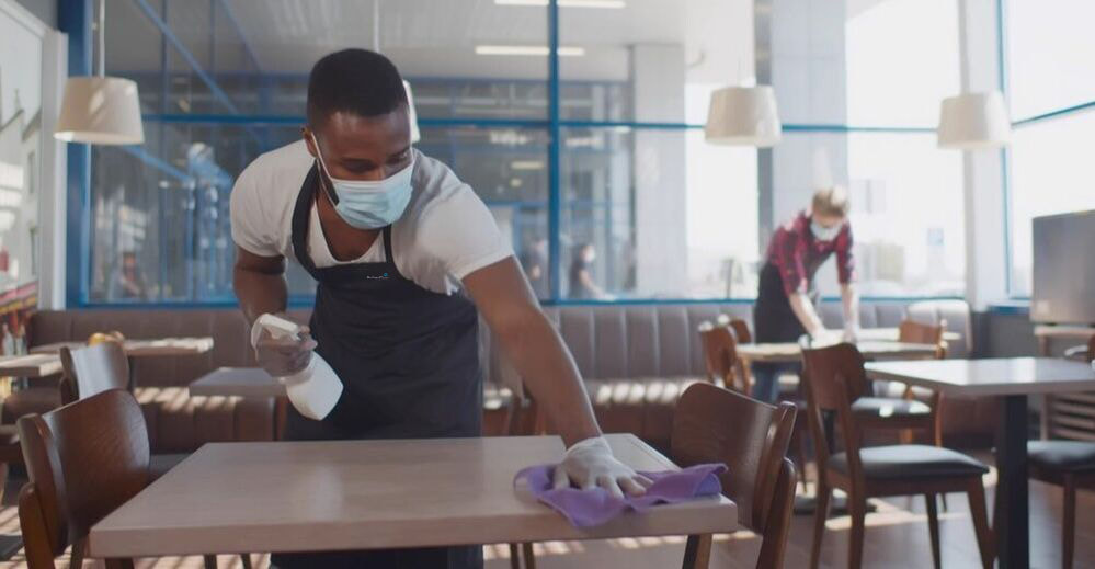 Picture of Man Cleaning Counter, He is wearing a mask