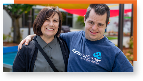 A Northwest Center Job Coach smiling next to an employee they support with disabilities